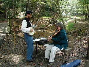 A Civil War re-enactor plays the banjo while an unknown woman plays the fiddle at Chief Logan State Park, September 2002.